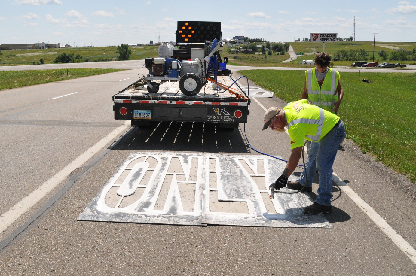 Workers painting signs on U.S. Highway 83. 