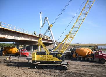 Crane and heavy construction equipment near bridge