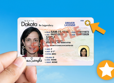 Hand holding a license with REAL ID.