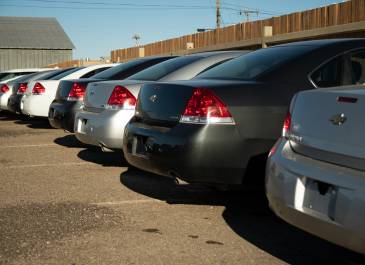 a row of cars parked in a lot awaiting auction