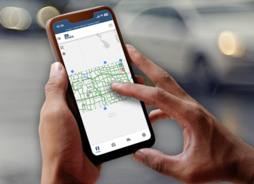 Hands holding a mobile device and using the ND Roads App.