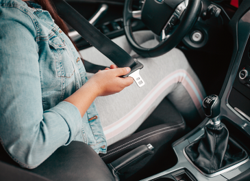 Woman putting on seat belt.