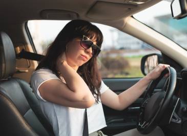 Tired driver rubbing her neck.