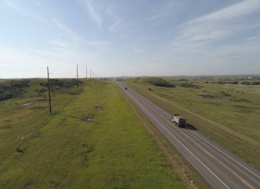 Stretch of two way US 85 roadway - Junction ND 200 North to RP 120.3. Green lush grass with blue sky.