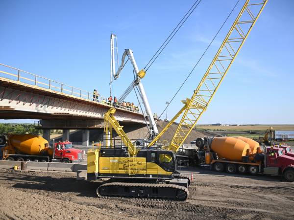 Crane and heavy construction equipment near bridge