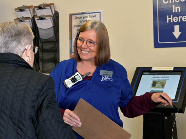 NDDOT employee helps citizen check in to an NDDOT site.