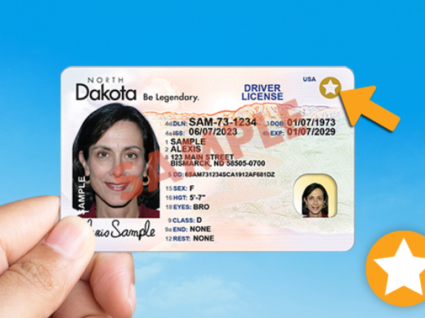 Hand holding a license with REAL ID.