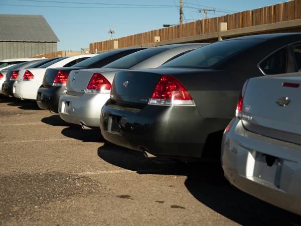 a row of cars parked in a lot awaiting auction