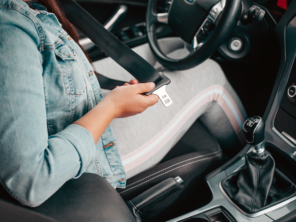 Woman putting on seat belt.