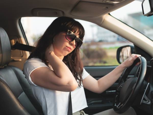 Tired driver rubbing her neck.