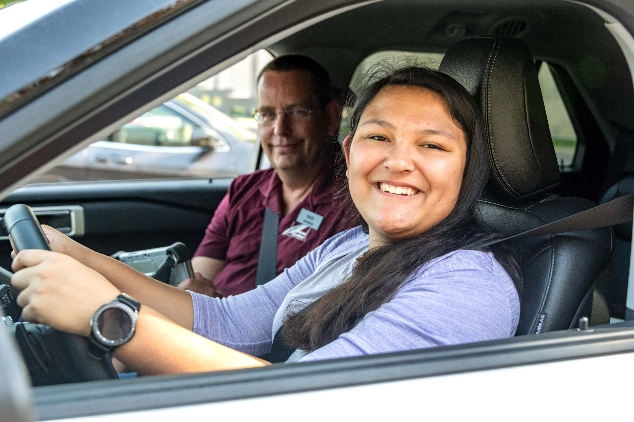 A young woman smiles proudly after passing her North Dakota driver test.