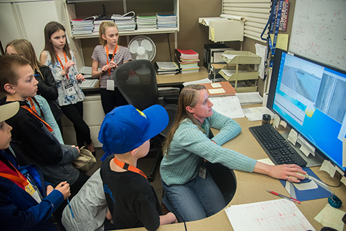 Pavement management program worker teaching kids.