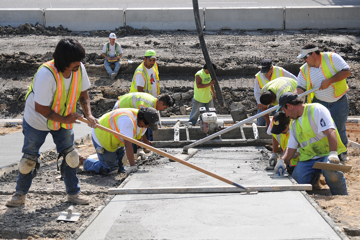 Construction crew working on some freshly laid cement.