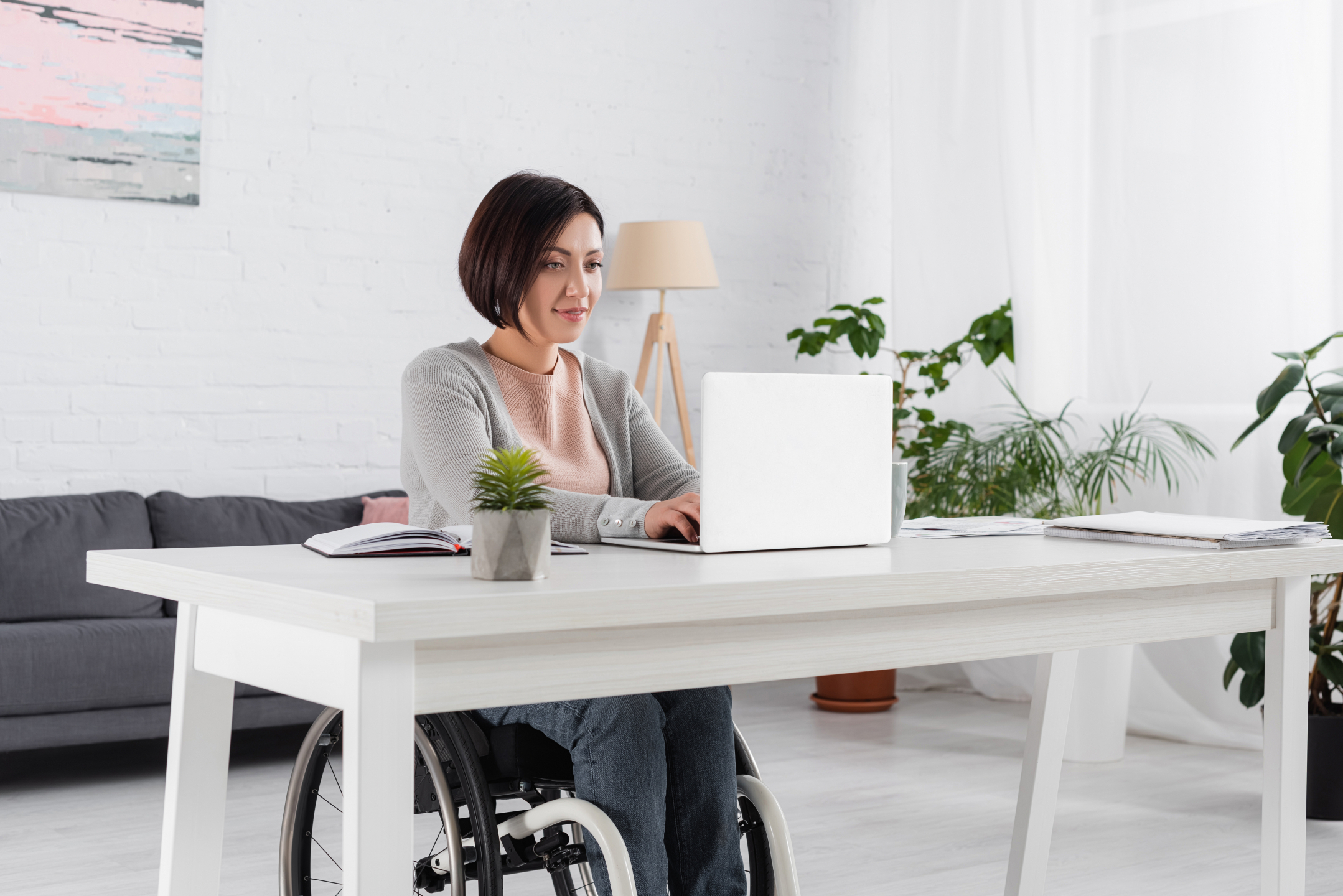 Woman in wheelchair using a laptop.