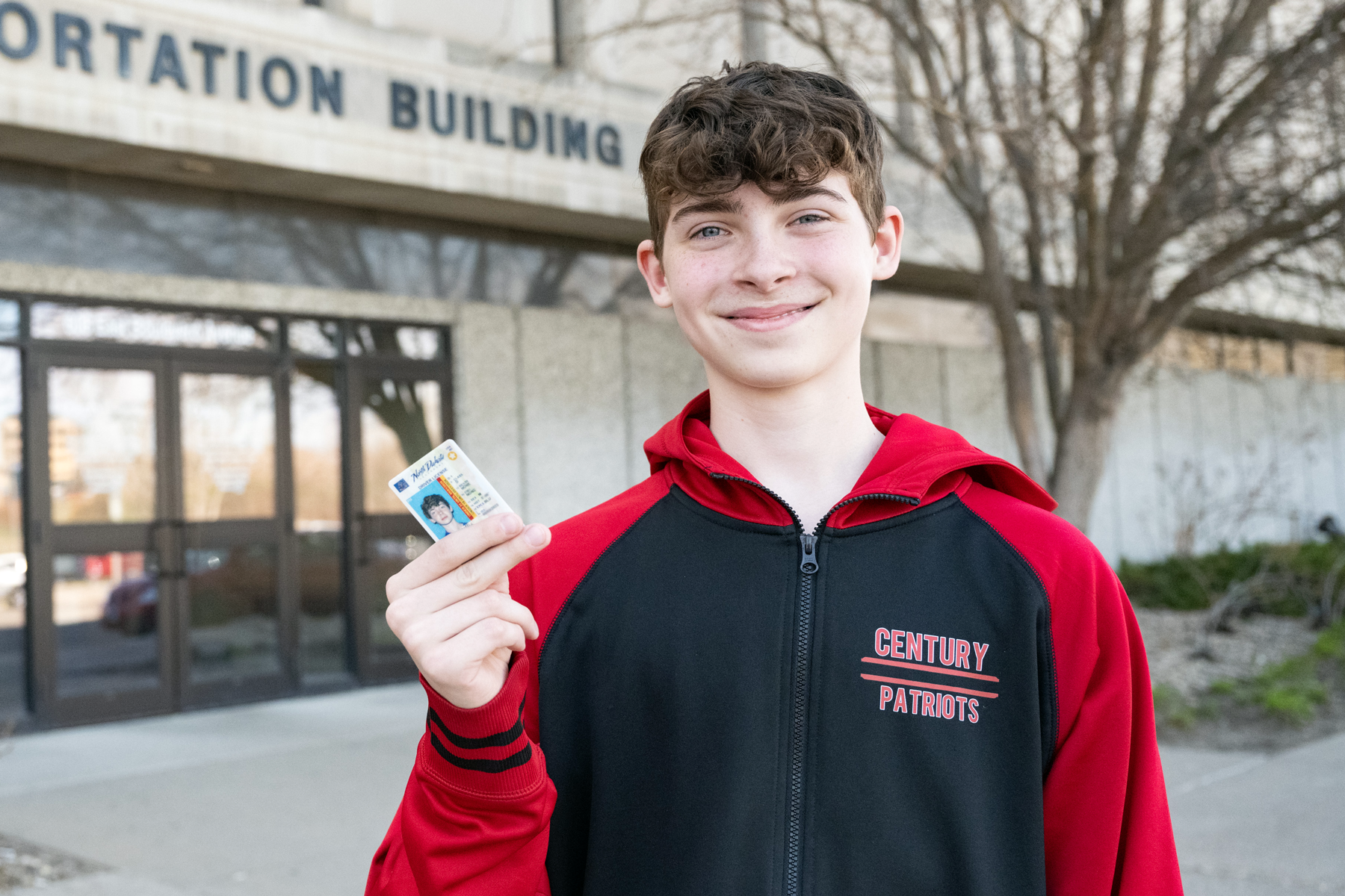 Teenage boy holding his new North Dakota driver license.