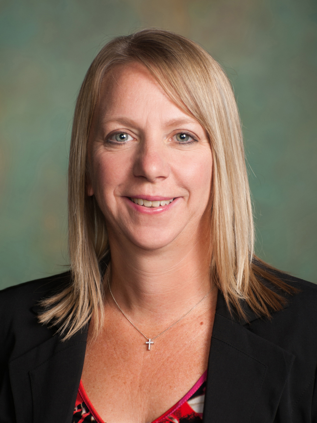 Smiling Robin Rehborg, Deputy Director for Driver Safety in front of multi-colored background.