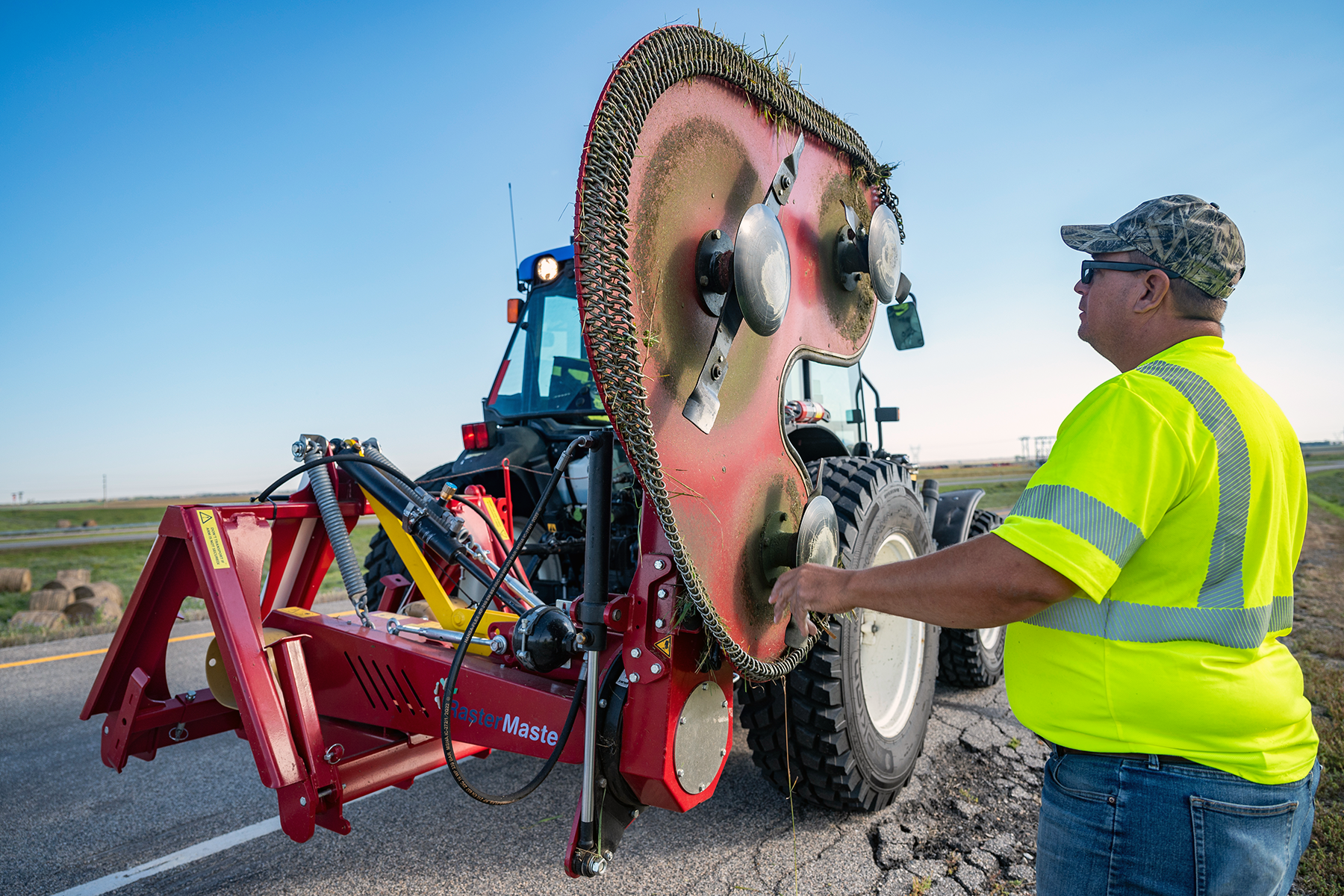 Equipment operator checks the blades on a Raster Master mower.