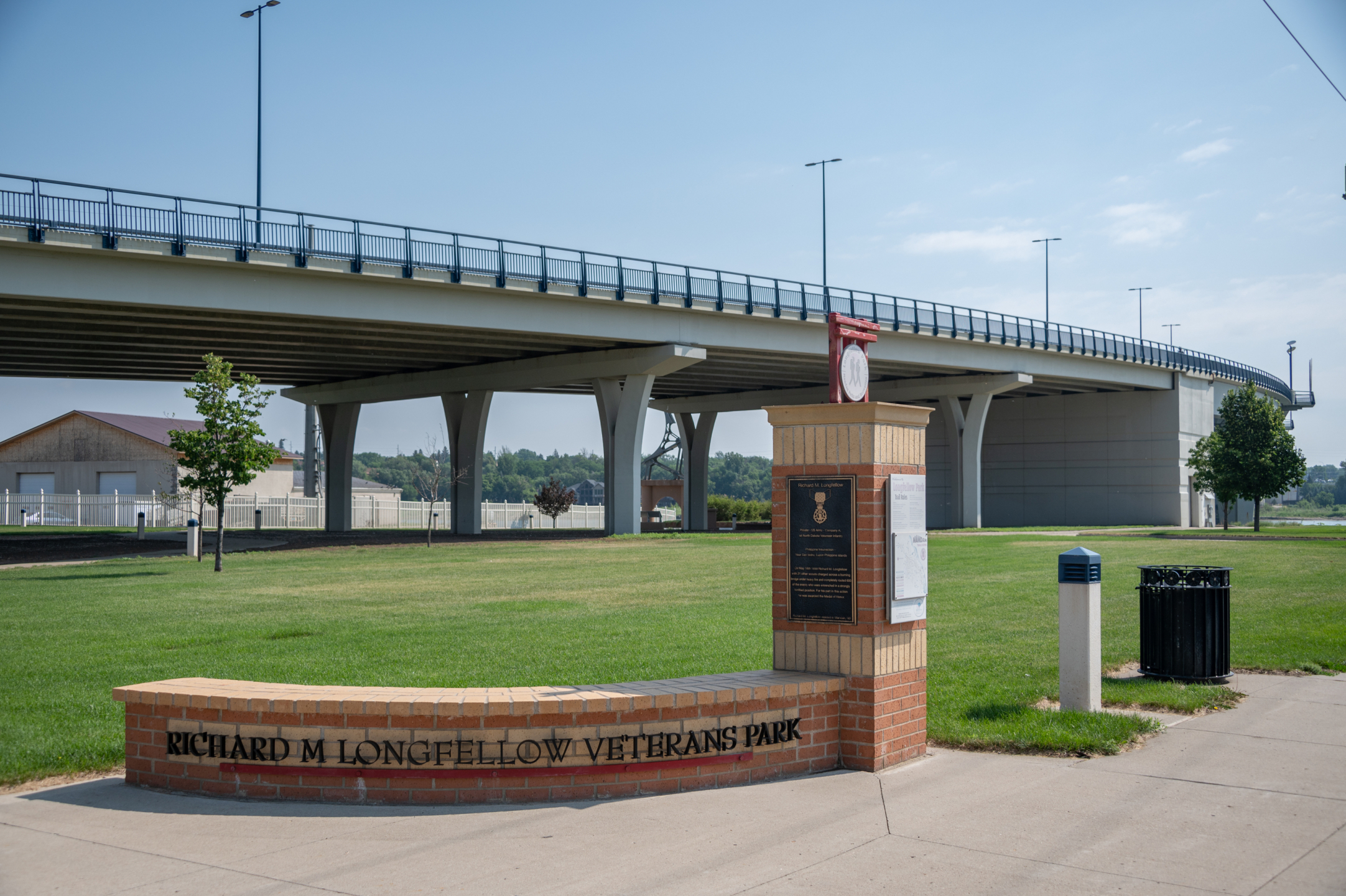 Long fellow veterans park, dedicated red and beige brick bench with overhang.