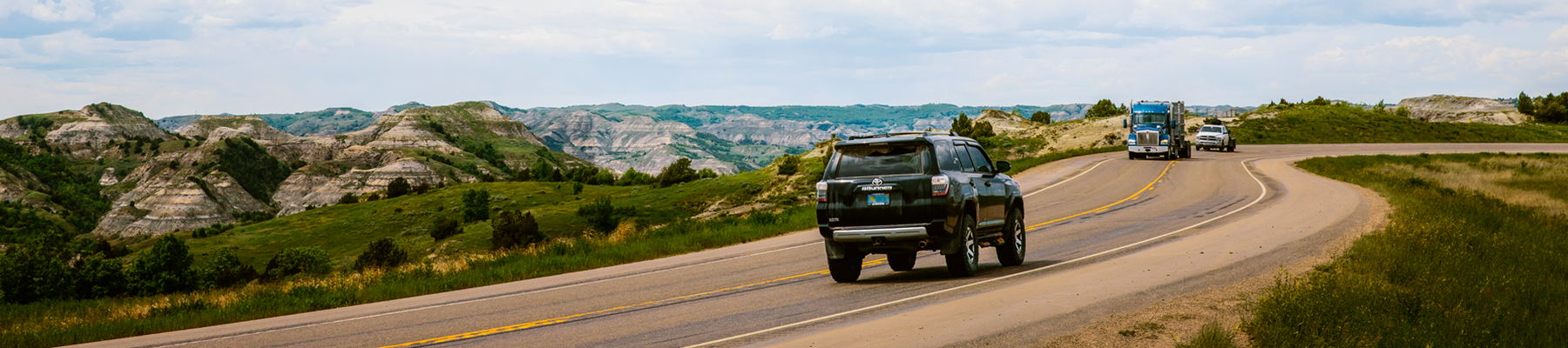 SUV drives on a road in Theodore Roosevelt National Park.