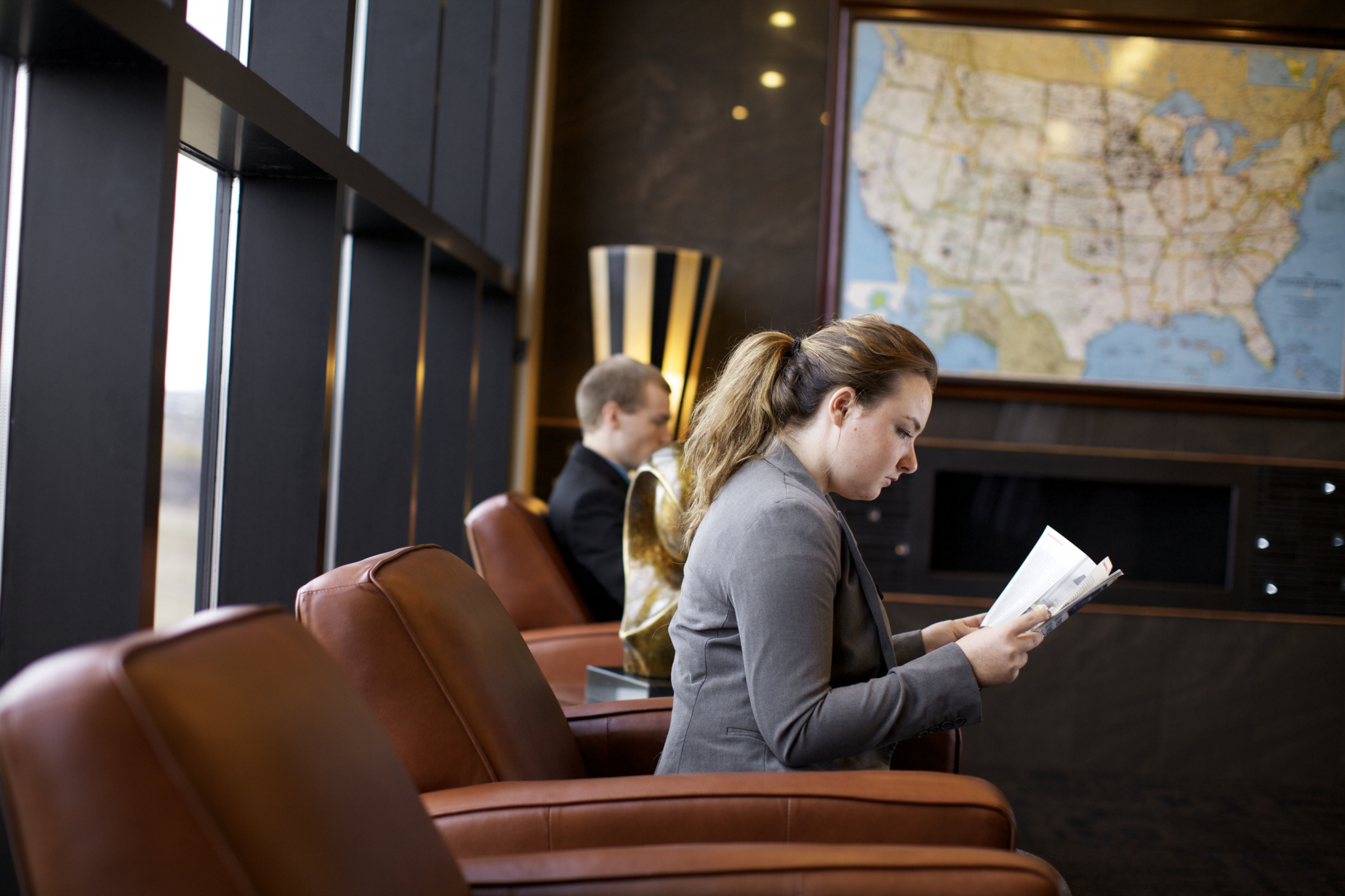 Woman inspecting papers while sitting in a chair in a waiting room