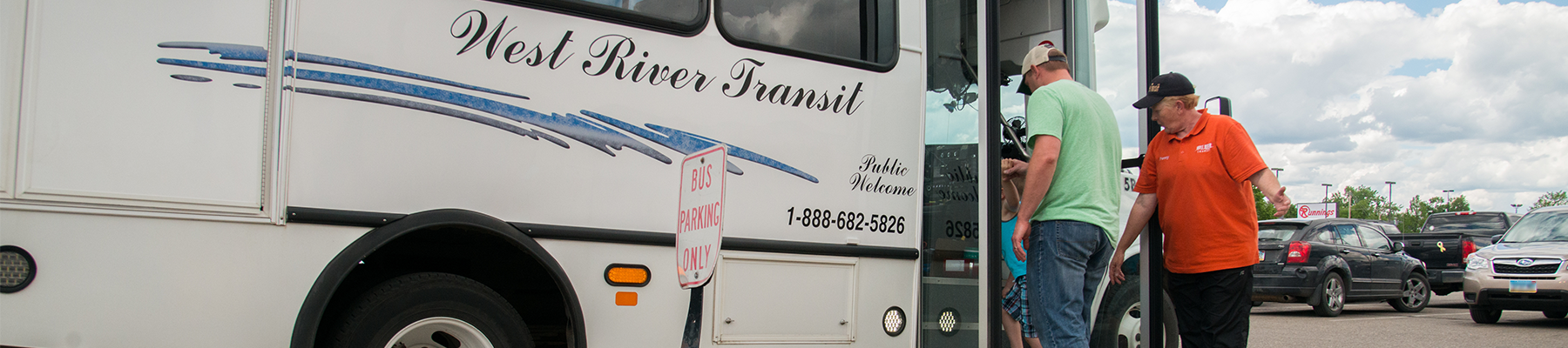 Citizen boarding a transit bus, assisted by the driver.