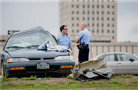 Car collision site, two officers, two damaged vehicles.