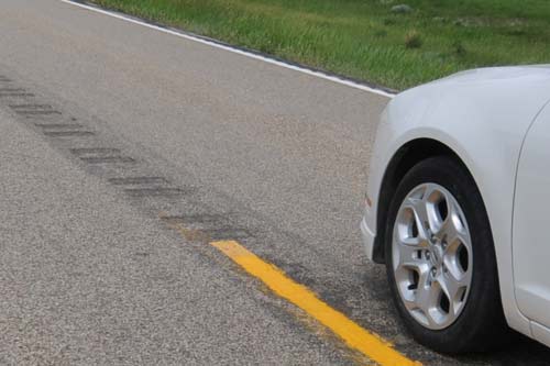 Car on road near rumble strip