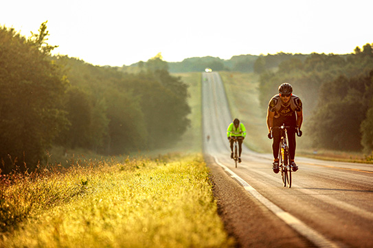 Two people bicycling on a rural ND road.