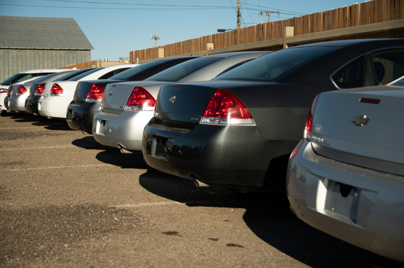 a row of cars parked in a lot awaiting auction