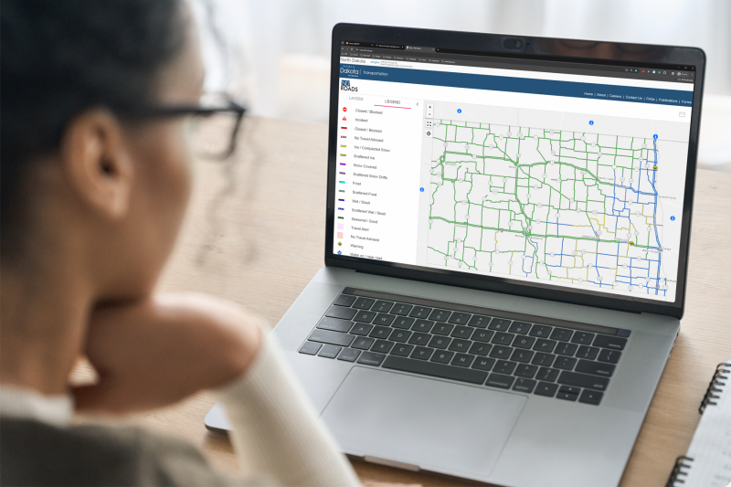 Traveling in North Dakota NDDOT - Woman Looking At Nd Roads Map On Laptop Computer 