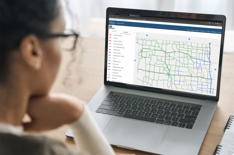 Woman looking at the ND Roads map on her laptop computer.